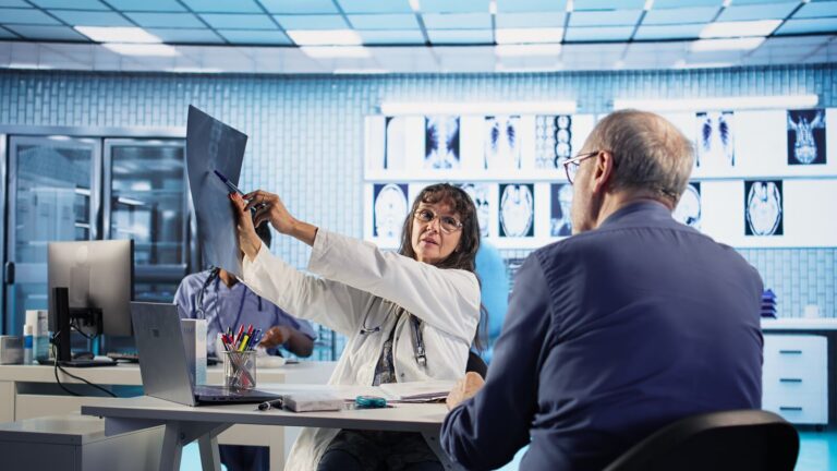 Médica mostrando exame de imagem a um paciente